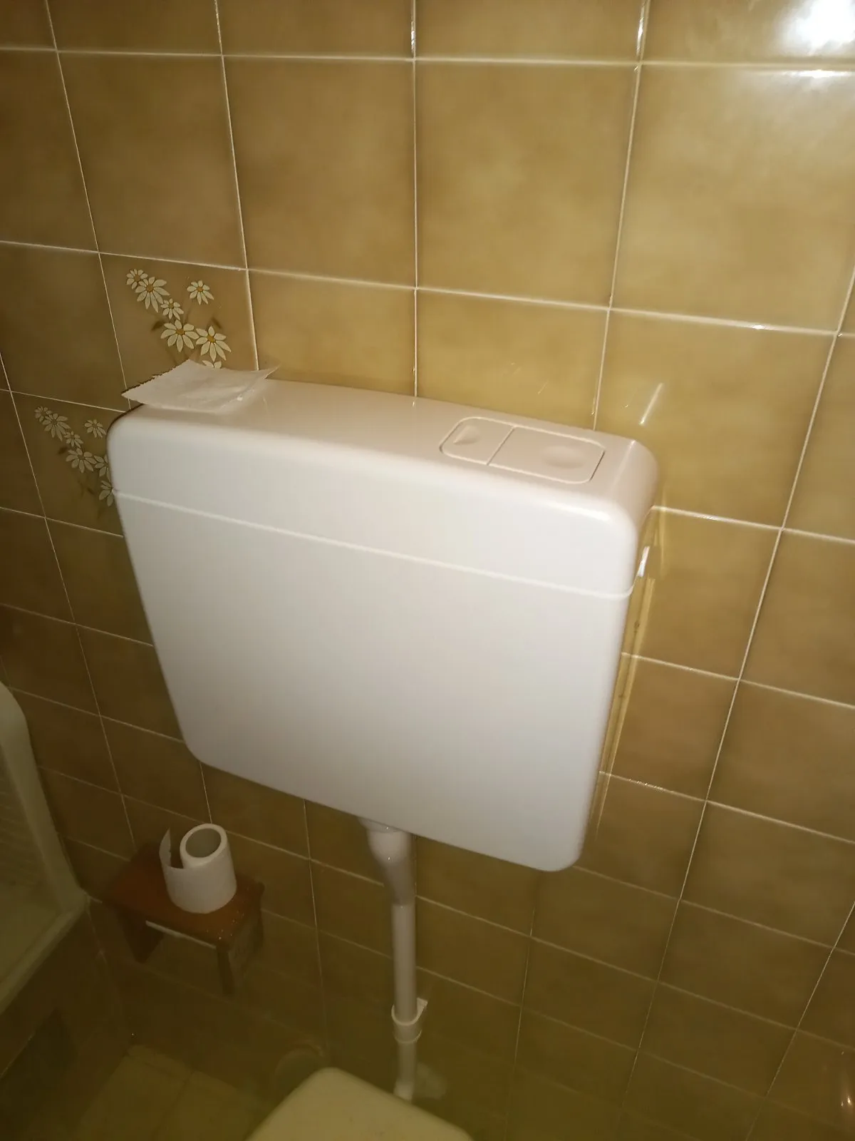 Cassetta wc esterna nuova, bianca, con doppio tasto sul coperchio e tubo di discesa fissato al muro sopra il vaso