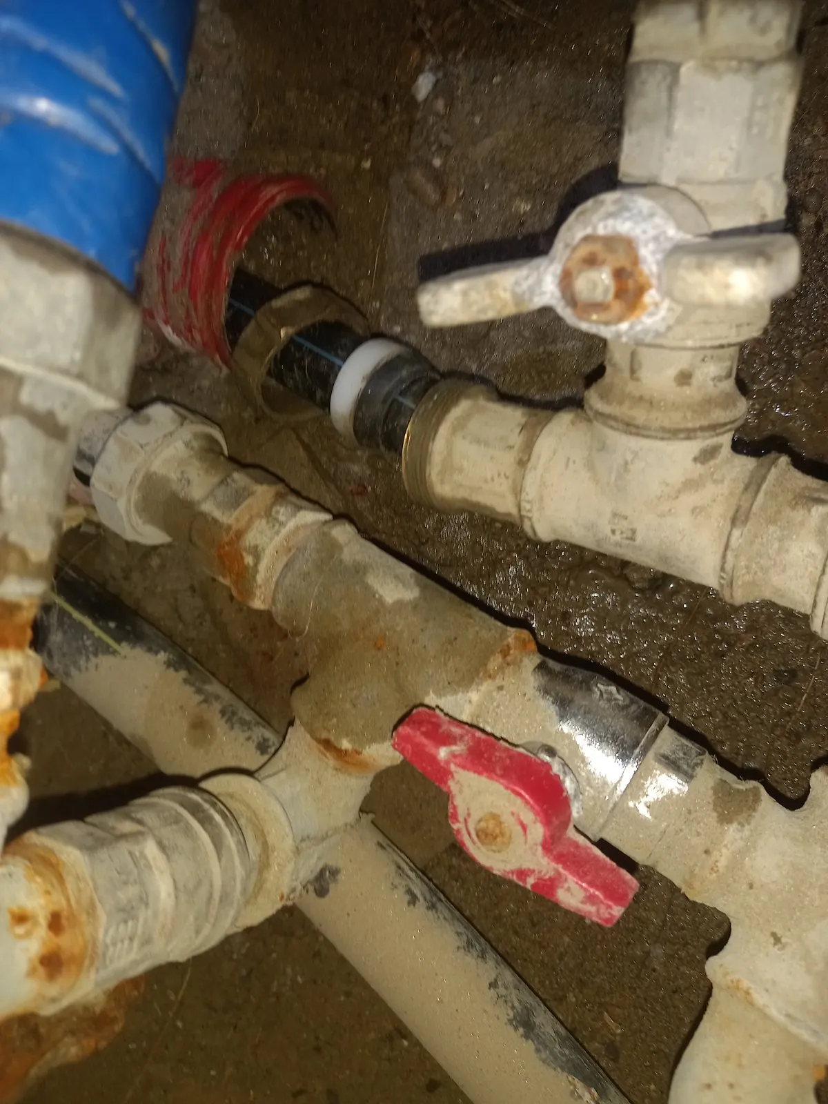 Tubo in polietilene che esce dalla guaina rossa e si collega con dado in ottone e anello bianco al raccordo a T delle valvole