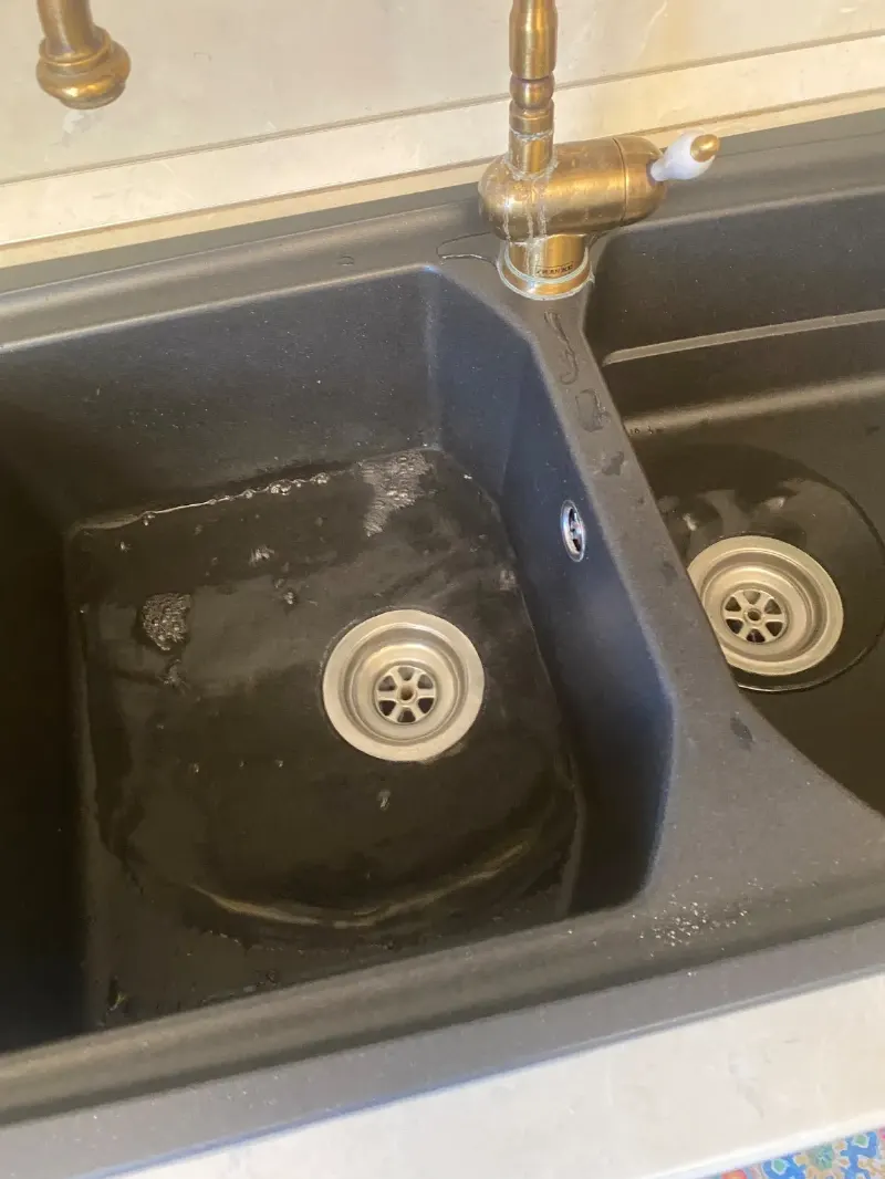 Lavello da cucina a due vasche con acqua ferma e schiuma nella vasca di sinistra che non scarica