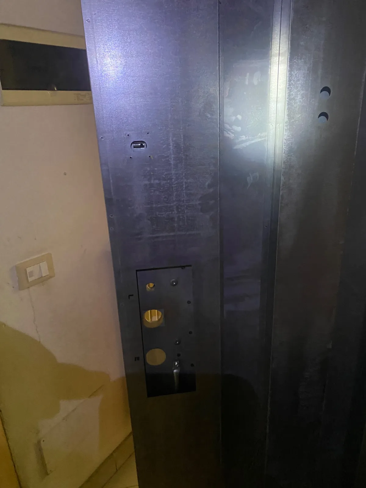 Anta di porta blindata senza pannello interno, con la sede della serratura vuota e i fori per chiave e maniglia