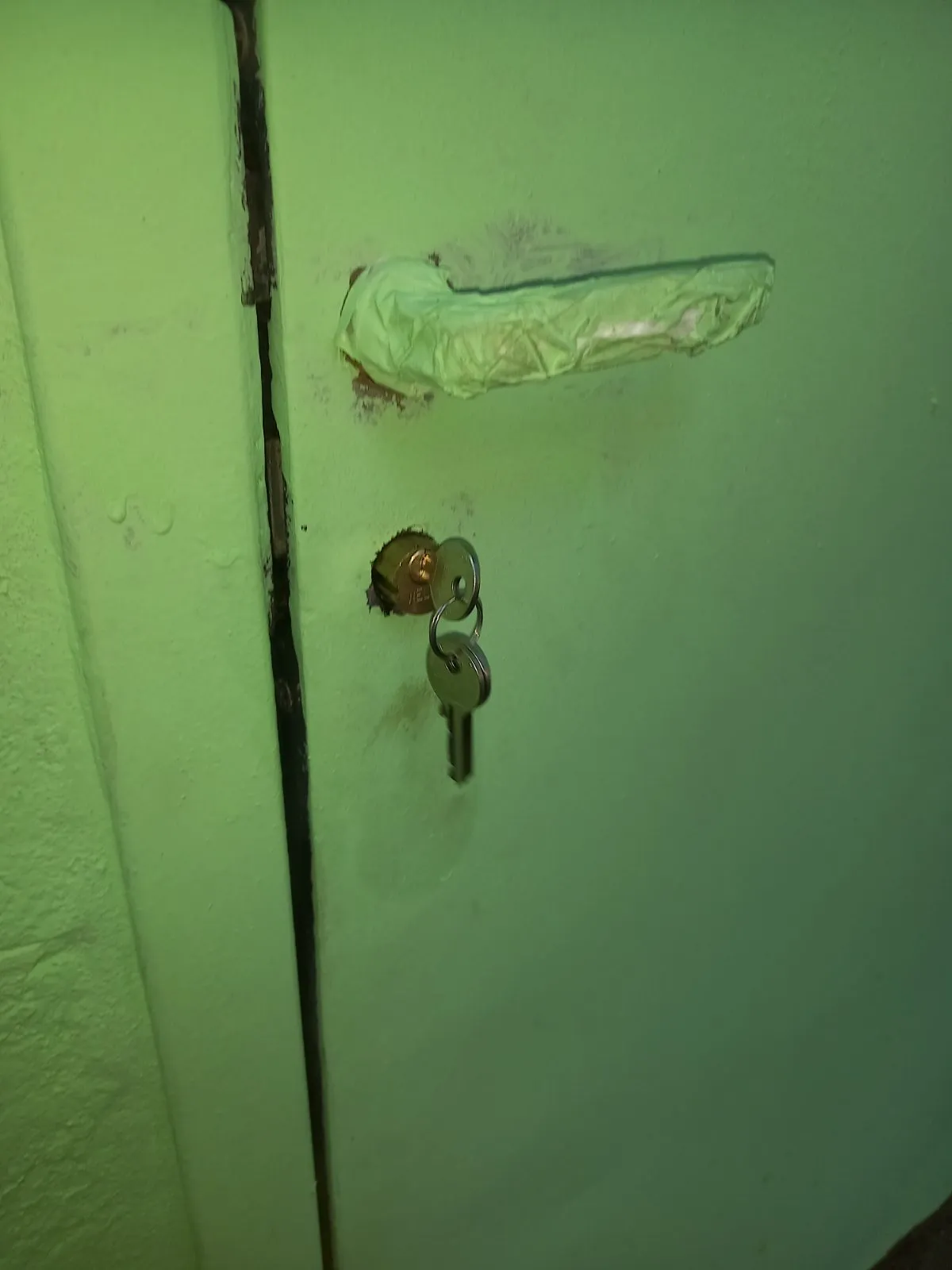 Porta del ripostiglio chiusa con il cilindro nuovo in ottone e le chiavi nuove nella serratura